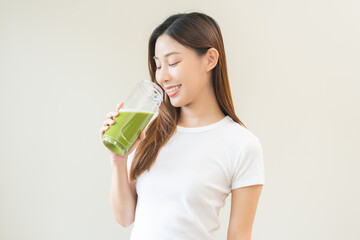 Green detox juice concept, Beautiful asian young woman hand holding vegetable smoothie bottle for...