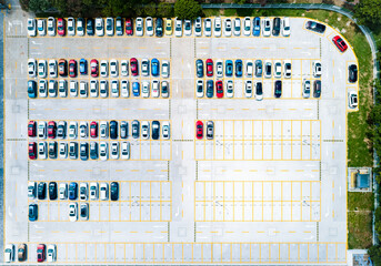 Aerial top down view a parking lot with cars of different colors. © Evgenii Bakhchev
