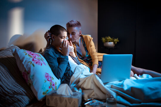 Young woman helping her sick girlfriend in the bedroom