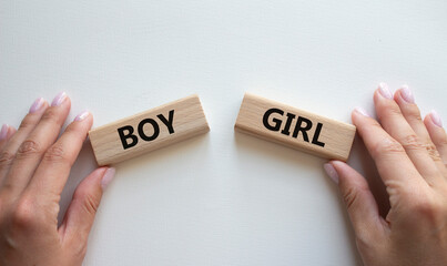 Boy or Girl symbol. Concept word Boy or Girl on wooden blocks. Man hand. Beautiful white...