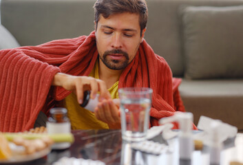 adult sick ill man hold pills on hand pouring capsules from medication bottle, take painkiller supplement medicine, people pharmaceutical healthcare treatment concept, close up view at home