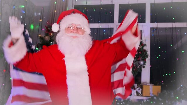 Сlose-up of happy Santa Claus dancing with a large American flag with patriotic emotions celebrating Christmas holidays against the background of holiday lights, close up.