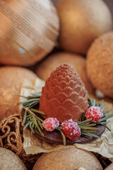Christmas sweets cupcake chocolate cone on wooden background with gold pine tree with bokeh light, New Year sign for card