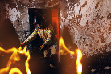 Fireman in burning wooden house clears rubble to save people and extinguish fire. Concept rescue services at work