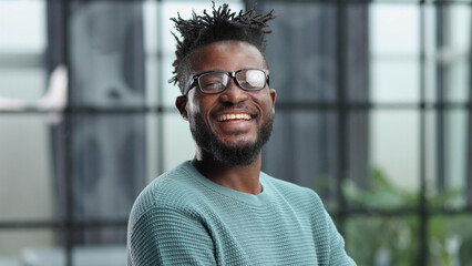 Thoughtful young black man in glasses looking straight ahead