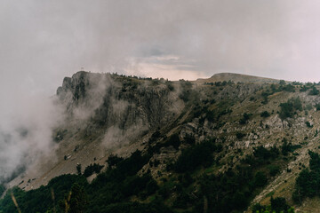 Landscape of rocky hilly mountains among low clouds
