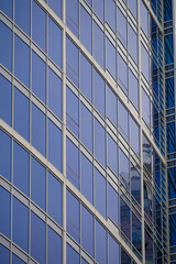 Obraz premium Modern glass office building with reflective windows in the city