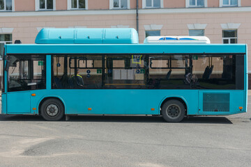 an empty city passenger bus stands on an asphalt road against the background of a building and a police officer