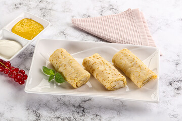 Homemade stuffed pancakes with honey and cream sour