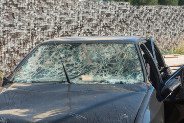 a passenger car after an accident with a broken windshield and crumpled doors