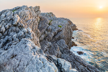 Coastal cliffs, the Atlantic ocean, and the sunset. Cantabria, Spain.