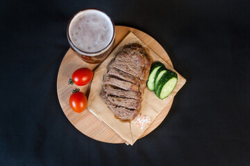 Fried meat with green vegetables with a glass of beer