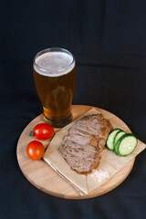 Fried meat with green vegetables with a glass of beer