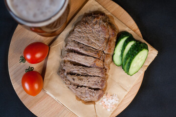 Fried meat with green vegetables with a glass of beer