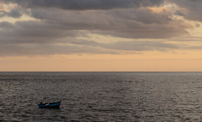 Row boat anchored in the atlantic ocean at sunset
