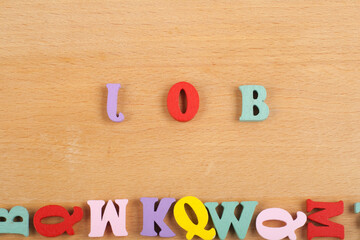 JOB word on wooden background composed from colorful abc alphabet block wooden letters, copy space for ad text. Learning english concept.