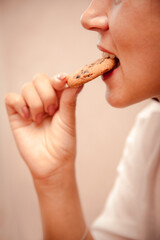 closeup mouth eat cookie. hungry woman quenches hunger with sweets between work