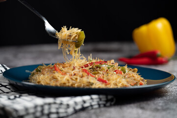 Asian salad with glass noodles, chicken, prawn, shrimp and vegetables on a gray background .