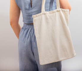 Carrying textile shopper, linen tote bag, standing back view