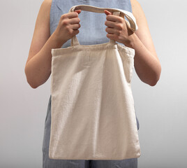 Advertising textile shopper, linen tote bag, holding totebag in hands