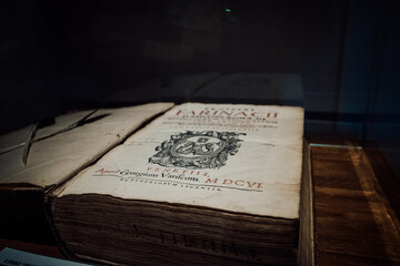 A worn tome rests atop a table, its text a treasure trove contained within its weathered pages