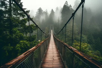 Rolgordijnen Suspension bridge in a dense green forest with pine trees © artsterdam