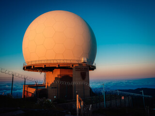 An ethereal sunset ignites the sky above a grand observatory in madeira, where a colossal white...