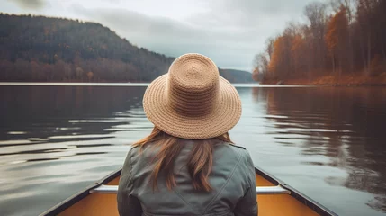 Foto op Canvas A serene image capturing a young woman paddling a canoe on a tranquil lake, surrounded by the breathtaking beauty of nature, embodying the spirit of freedom and adventure. © TensorSpark