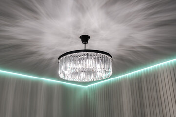a chandelier on a white ceiling. the light falls beautifully on the ceiling from the chandelier.
