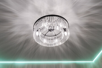 a chandelier on a white ceiling. the light falls beautifully on the ceiling from the chandelier.