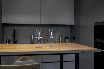 the kitchen is in shades of gray. Appliances. Wooden table and glass glasses