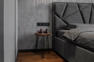 the bedroom is in gray tones. a grey bed. soft light in the bedroom