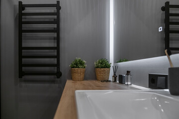 the bathroom is in gray shades. Bathroom with wooden countertop and white sink
