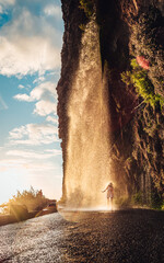 Lost in the misty embrace of madeira, a traveler gazes in awe at the cascading waterfall,...