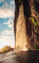 Washable wall murals Deep brown Lost in the misty embrace of madeira, a traveler gazes in awe at the cascading waterfall, surrounded by the vibrant hues of the portuguese landscape and the endless expanse of the sky above, grounded