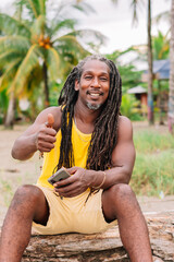 Vertical image of an African American man with his thumb up in a positive attitude. Rasta hair man...