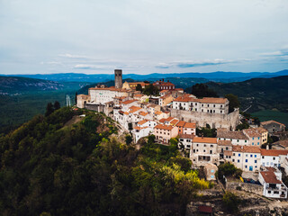 Amidst the vastness of nature's canvas, a city on a hill stands tall, its buildings and castles...