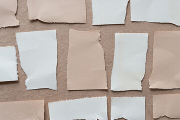 torn beige and ivory paper tiles on brown