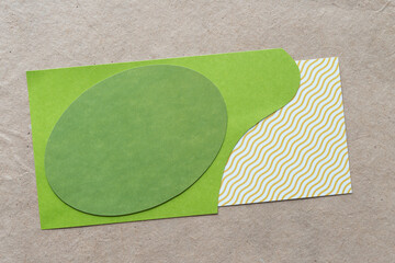 green oval on cut paper shape and paper tile with squiggly angular lines