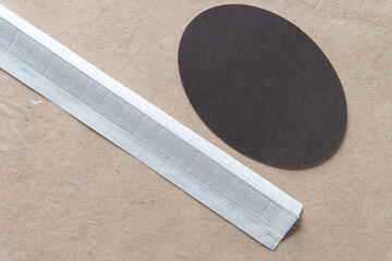 dark paper oval and stripe on plain brown paper
