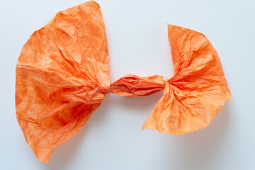 twisted orange tissue paper object with tufted ends