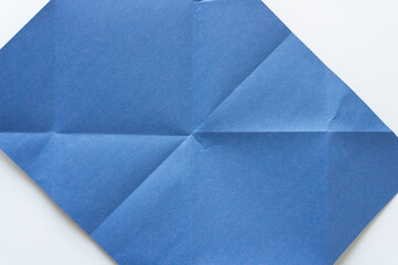 angled blue construction paper with geometric or crease line pattern on white