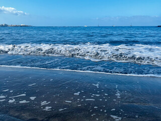 Naklejka premium Small ocean waves on the beach. Tenerife. Canarian Island. Amazing sky.