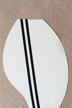 part of a rounded paper shape with parallel lines on plain brown paper