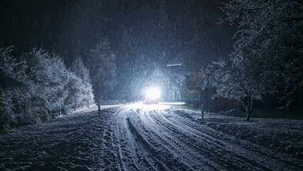 Snowfall on the road at night and the car light