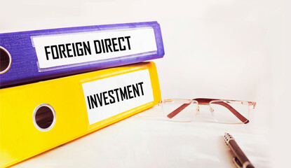 Foreign direct investment FDI written on colorful folders on a white table