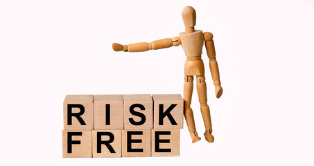RISK-FREE words on a wooden block and a white background with a wooden doll.