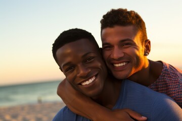 Homosexual gay couple embracing on beach at sunset. Men hugging each other  with tender. The couple at honeymoon in vacation near the ocean. LGBT concept - obrazy, fototapety, plakaty