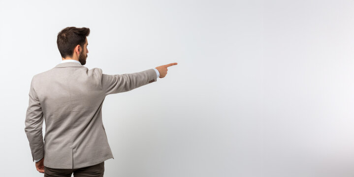 With his back to the camera, a man gestures towards an open area, adding an element of mystery and prompting viewers to explore the blank canvas, copyspace