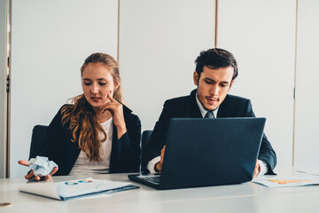 Unhappy serious businessman and businesswoman working using laptop computer on the office desk. Bad...